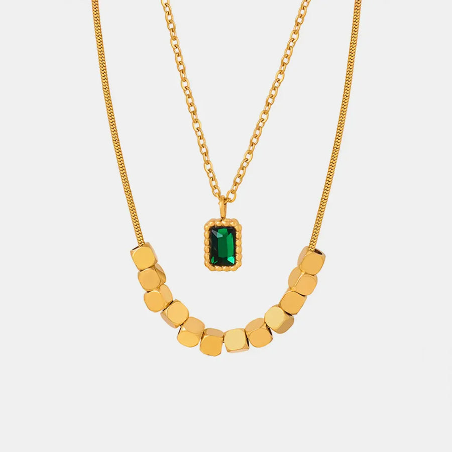 Gold layered necklace with emerald cube pendant and gold bead accent