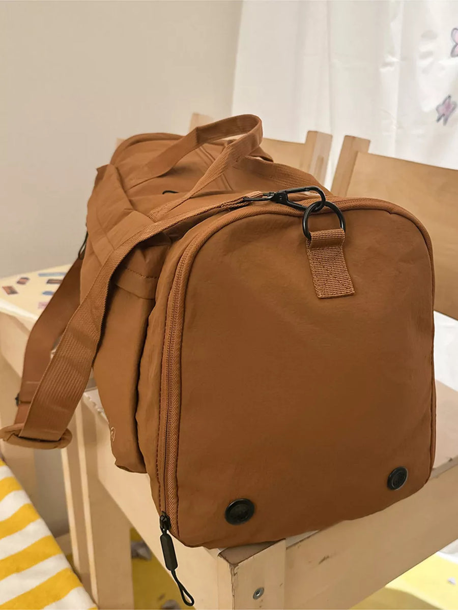 Caramel oxford cloth travel organizer bag with detachable strap and zippered compartments.