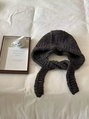 Cozy wool earflap beanie hat in Hemp Gray with ear ties and chunky knit texture.