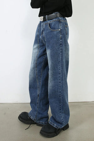 Panel seam wide leg denim jeans in medium wash, styled with a black belt and chunky shoes.
