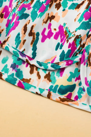 White running shorts with a colorful abstract brushstroke print and white stitching detail.