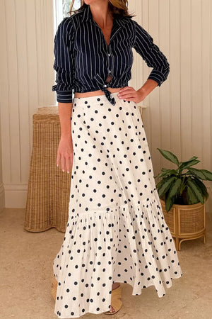 Chic polka dot maxi skirt in white with black dots, featuring a ruffled hem.