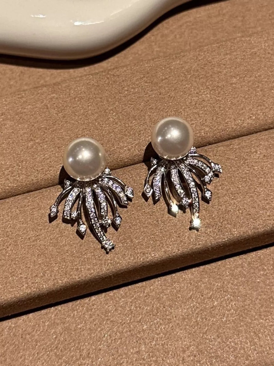 Luminous pearl and zircon silver earrings with intricate detailing.