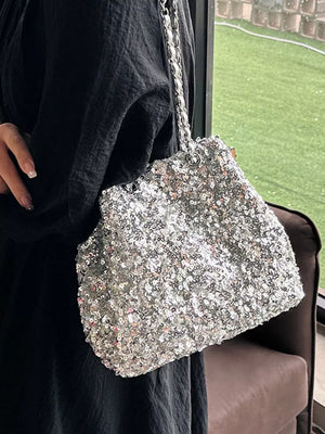 Dazzling sequin bucket bag in silver with a chain strap.