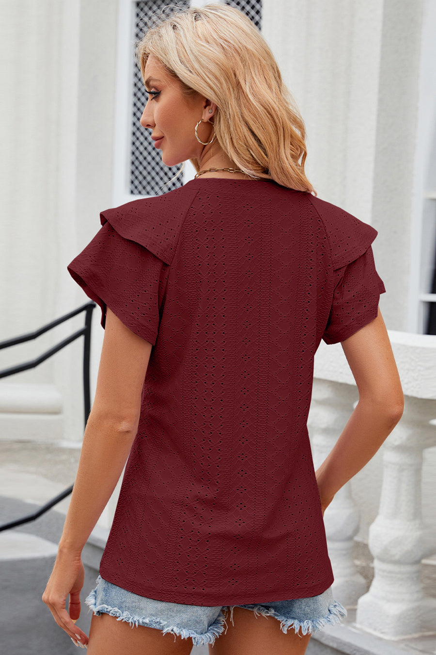 Burgundy eyelet blouse with flutter sleeves and a textured pattern.