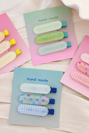 Pastel patterned hair clips trio in pink, blue, yellow, and gum leaf colors with assorted designs.