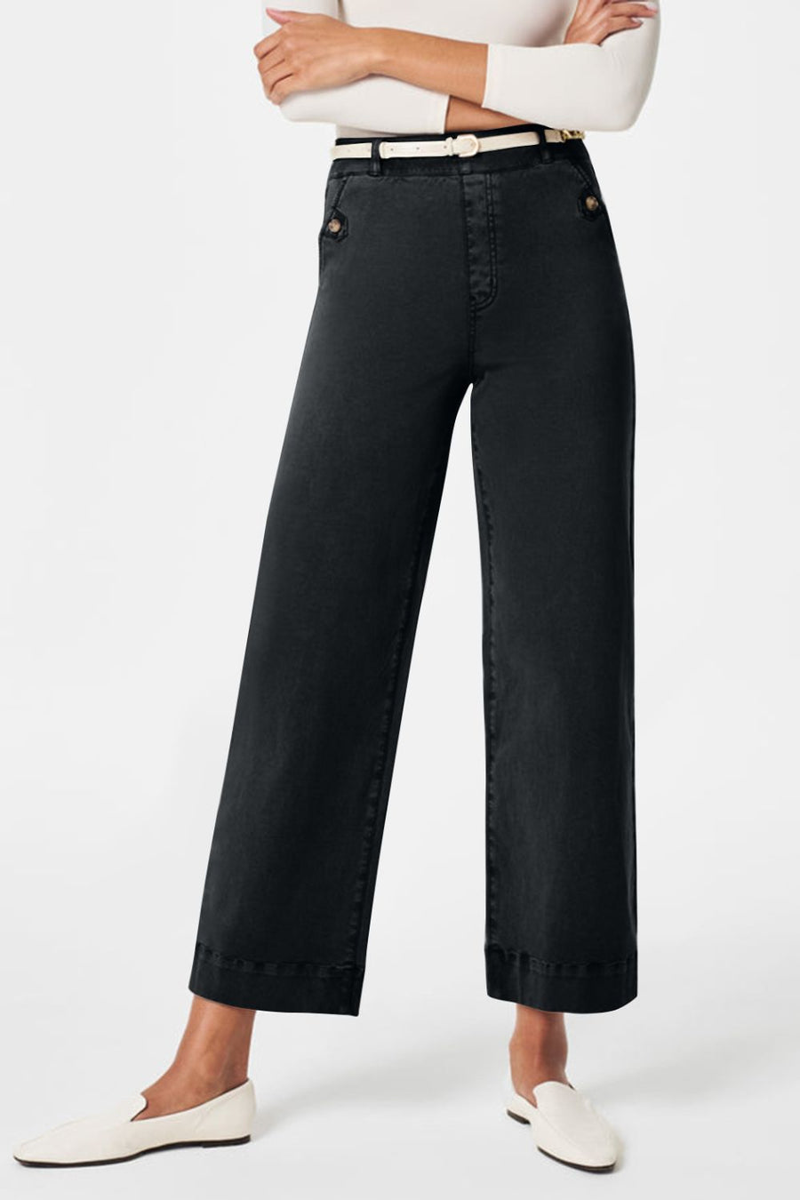 Wide-leg dark gray denim trousers with button details and a white belt.