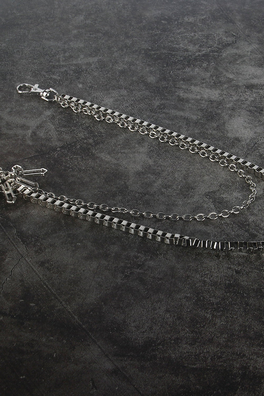 Silver geometric chain waist accessory with crossed charms and lobster clasp.