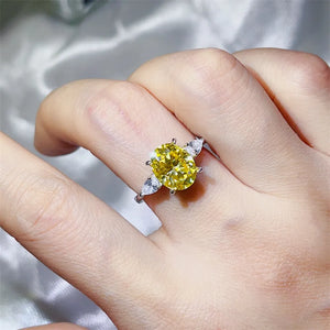 ring in yellow featuring oval cut and three-stone fit