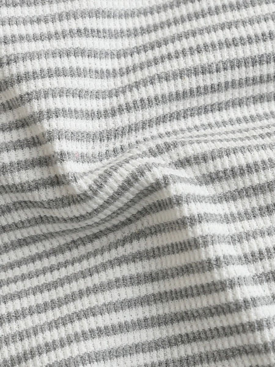 Baby one-piece with grey and white horizontal stripes in waffle knit fabric.
