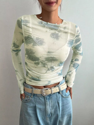 Sheer long sleeve t-shirt with a floral print, crew neck, and ruched sides.