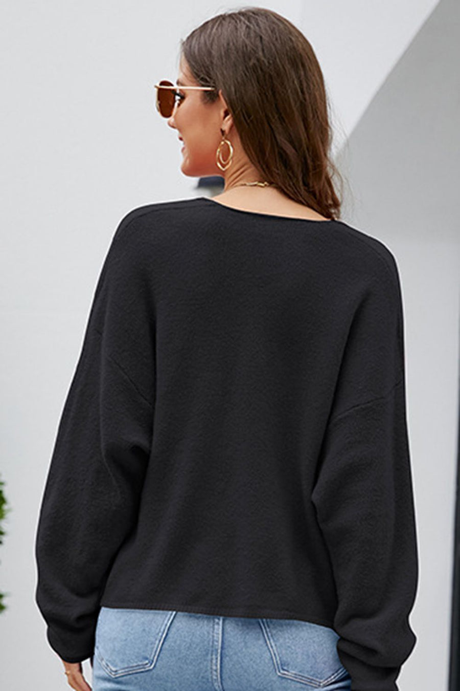 Black textured knit pullover sweater with a deep V-neck and long sleeves.