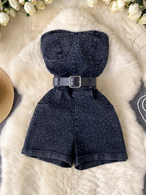 Black denim strapless romper with rhinestone embellishments and belted waist.