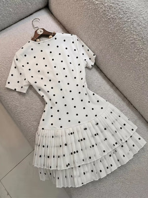 black mini dress featuring tiered and polka dot