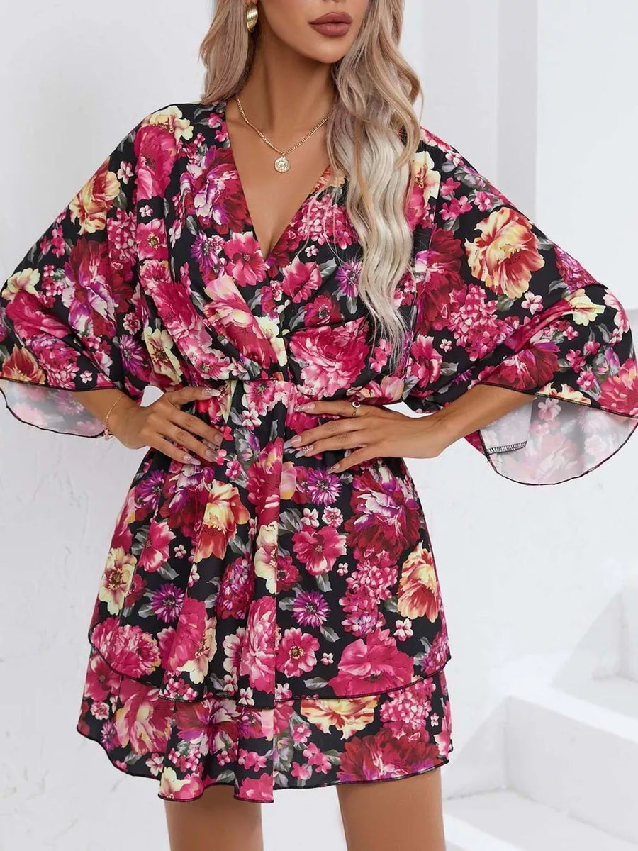 Floral ruffle hem mini dress in black with pink and yellow flowers, V-neck, and flutter sleeves.
