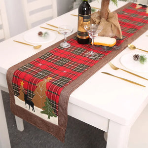 Festive plaid table runner in deep red with Christmas tree and reindeer appliqué.