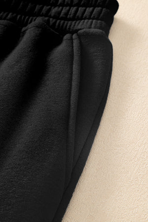 Black relaxed fit joggers with cargo pockets and elastic waistband detail.