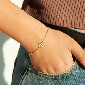 Gold crown charm bracelet with colorful enamel beads on a sterling silver chain.