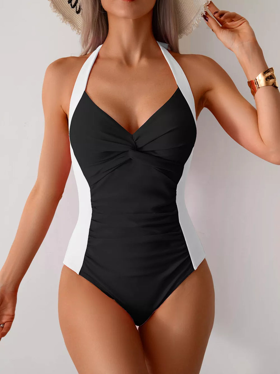 Black and white halter one-piece swimsuit with twisted front and ruched sides.