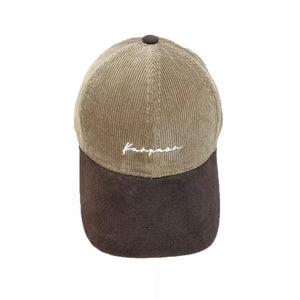 Two-tone corduroy baseball cap in camel and dark brown with white embroidery.