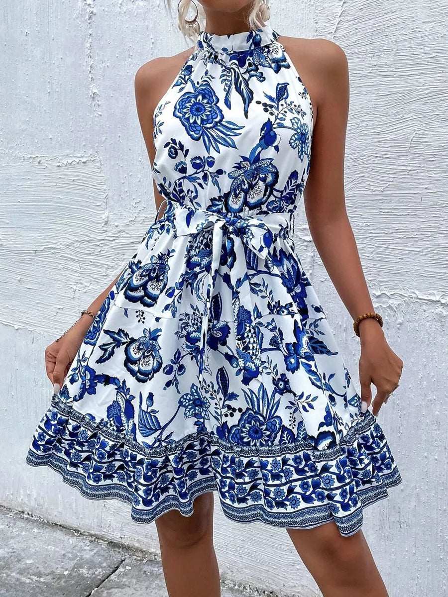 Floral print halter dress with tie waist and ruffled hem in royal blue.