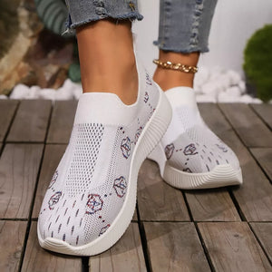 White breathable mesh slip-on sneakers with a geometric pattern.