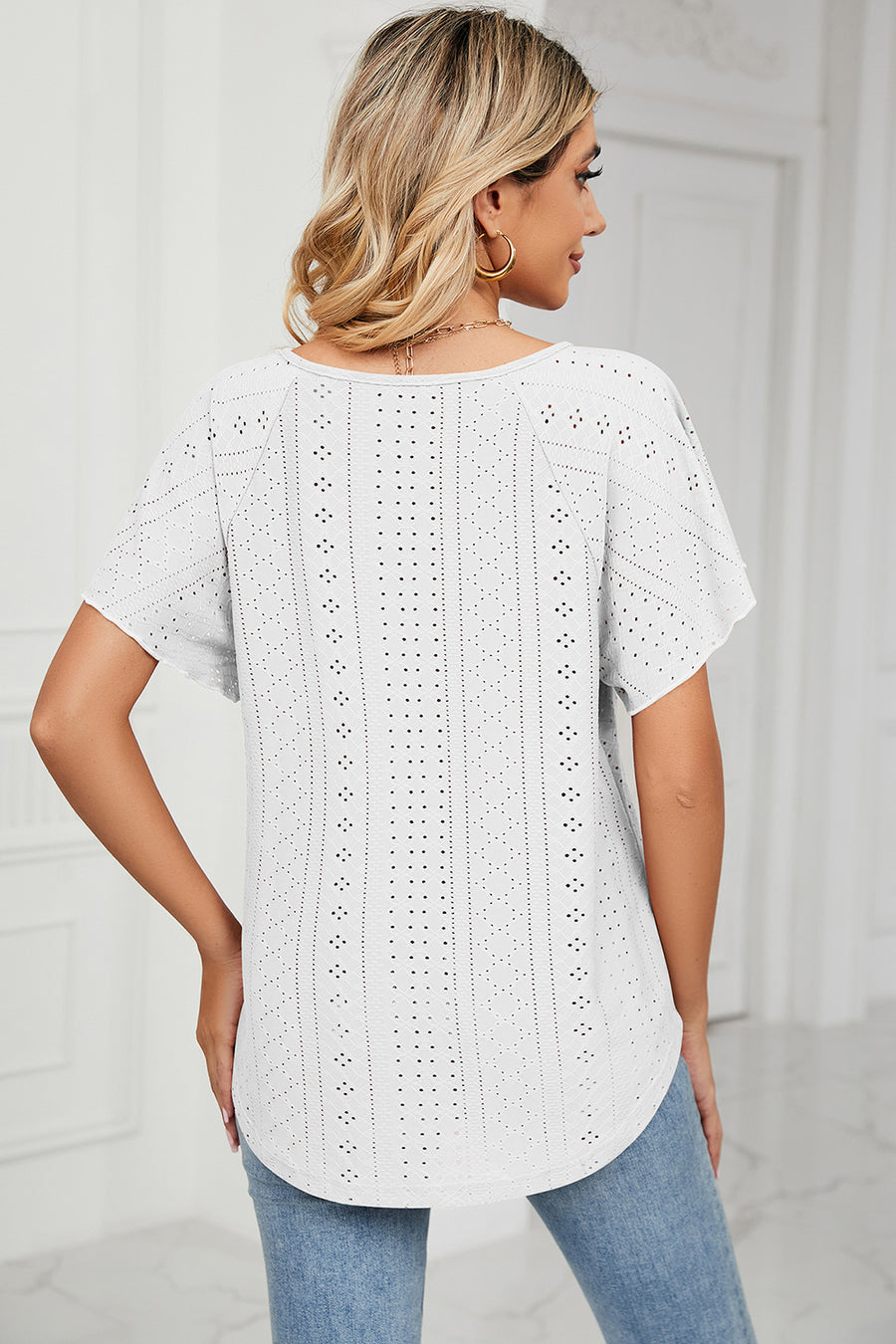 White eyelet blouse with flutter sleeves and scoop neck.
