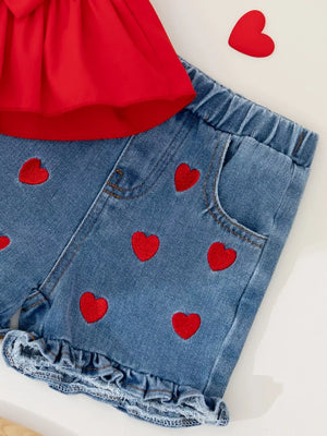 Red bowknot top with denim shorts featuring red heart embroidery and ruffled hem.