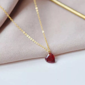 Gold chain necklace with a faceted red heart pendant