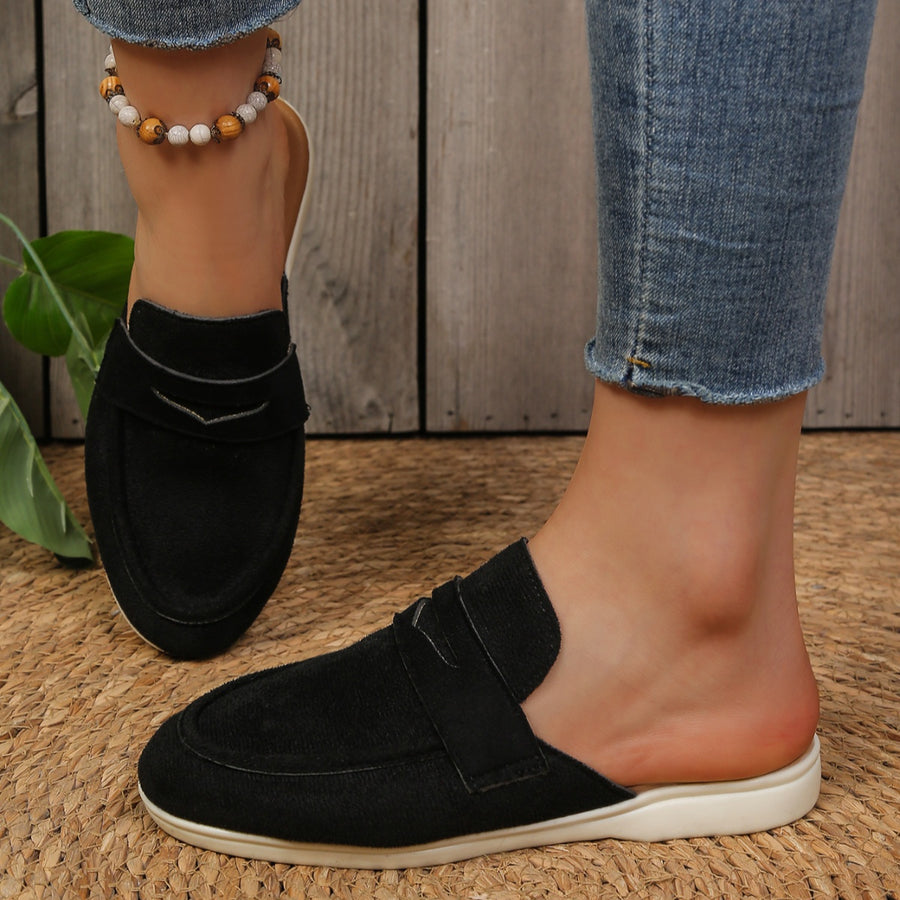 Black textured round toe slip-on loafers with a backless design.