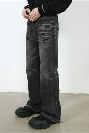 Distressed dark wash flare jeans with ripped details and frayed hems.