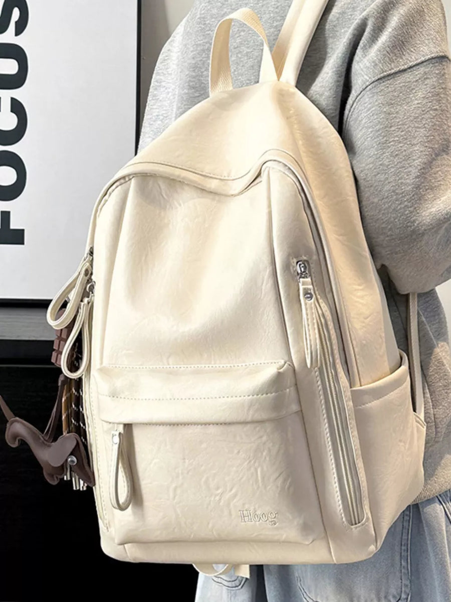 Chic white pu leather medium backpack with multiple zippered pockets and a cute dog charm.