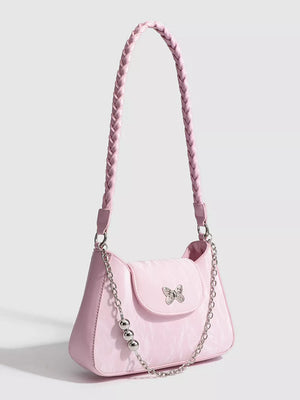 Pink shoulder bag with braided strap, butterfly charm, and silver chain detail.