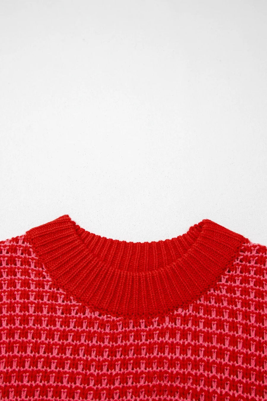 Red crew neck sweater with pink and red crochet detail knit pattern.