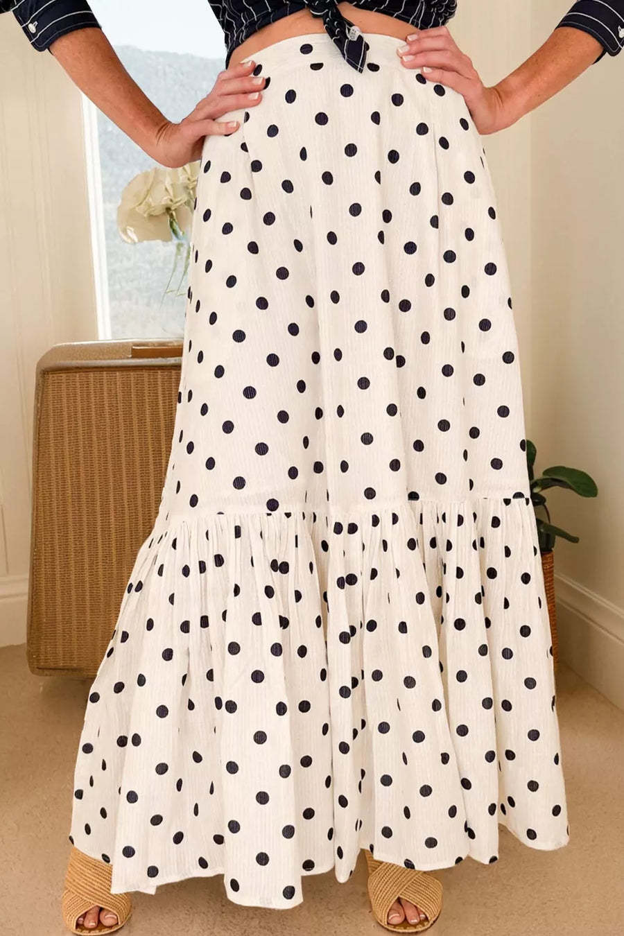 Chic polka dot maxi skirt in white with navy dots and ruffled hem.