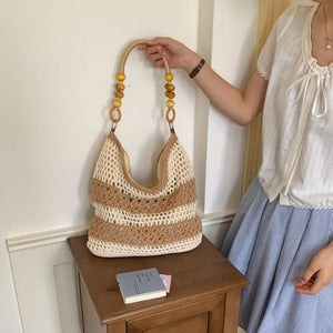 light brown handbag featuring crochet knit and striped