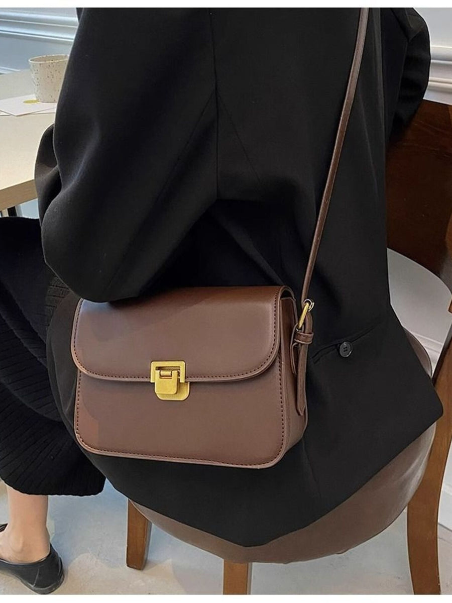 Brown shoulder bag with gold buckle flap detail