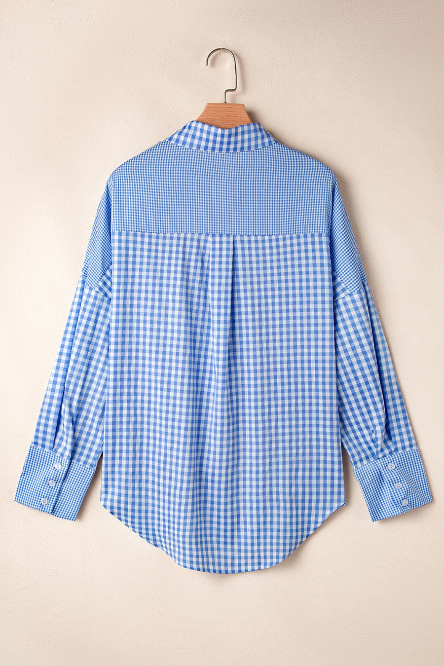 Light blue gingham oversized shirt with button cuffs and a patch pocket detail.