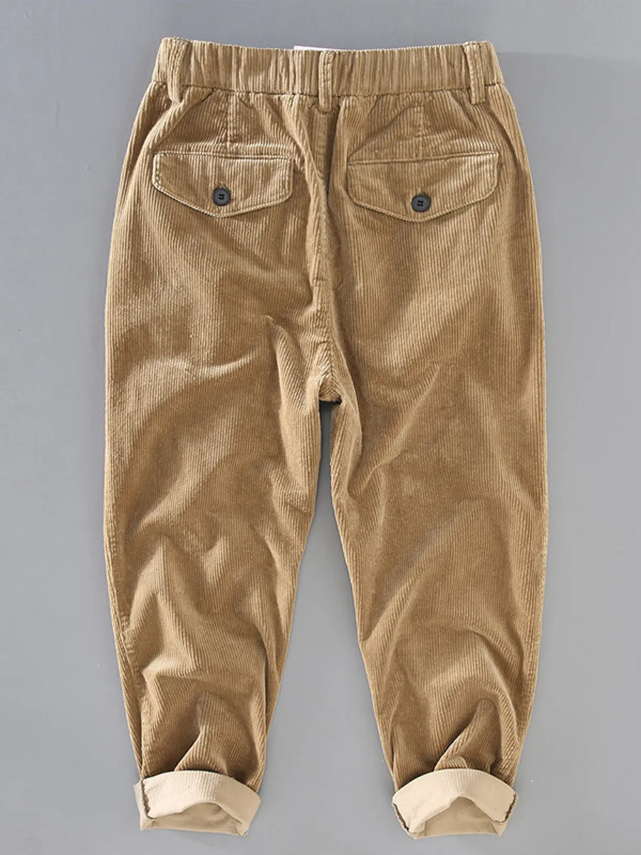 Khaki corduroy pants with elastic waist and button flap back pockets.