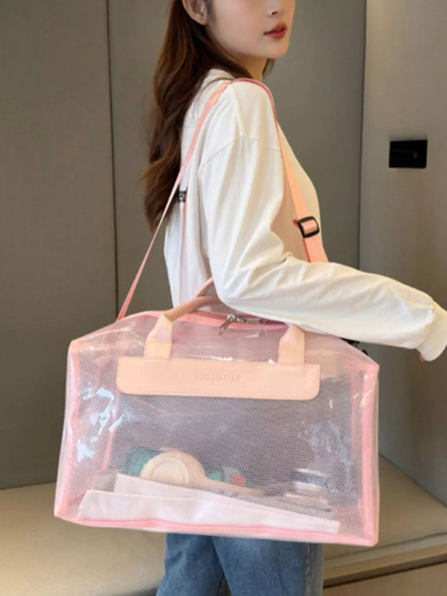 Chic transparent PVC travel bag in pink with mesh detail and pink straps, holding toiletries.