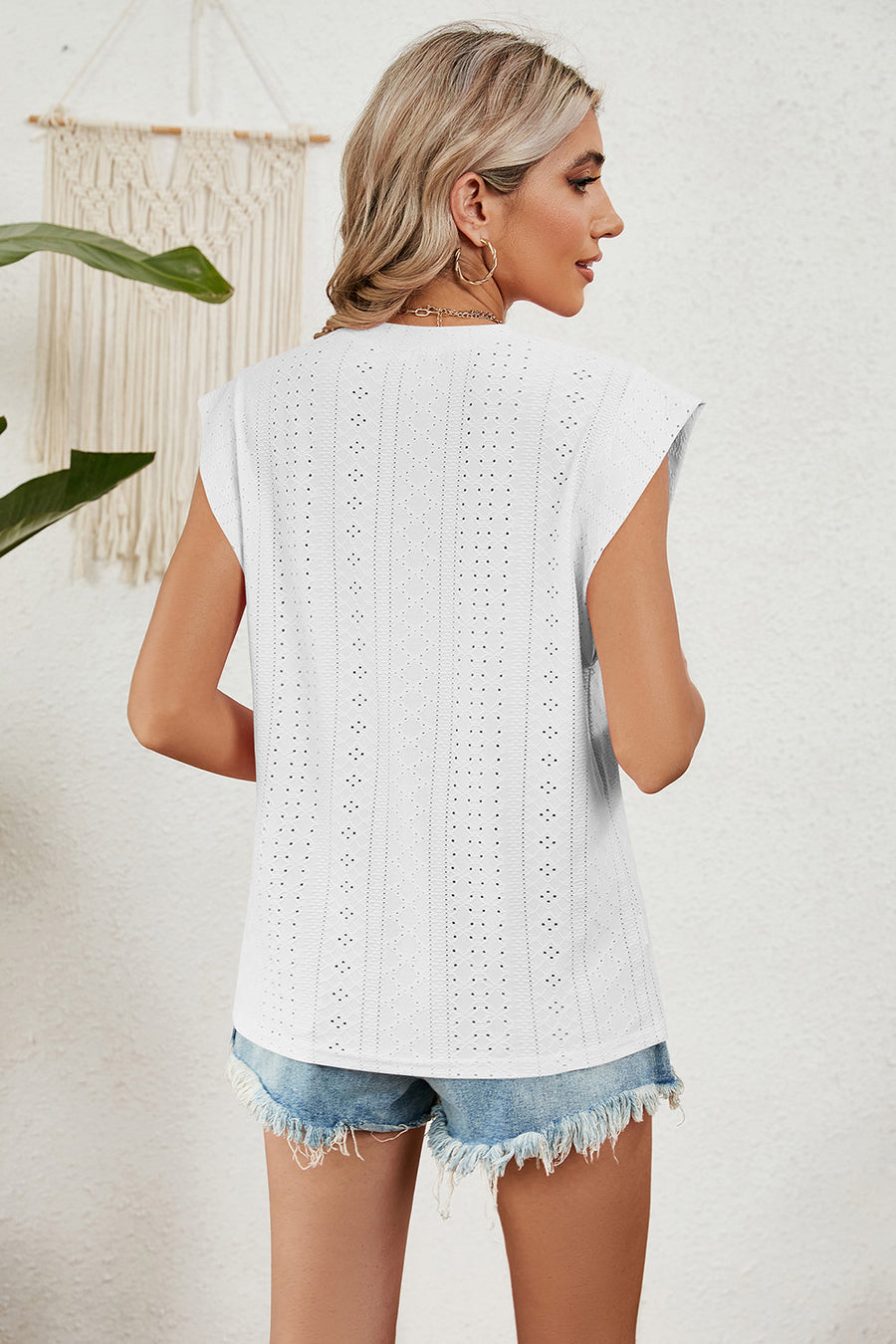 White perforated shoulder-pad top with cap sleeves and a relaxed fit.