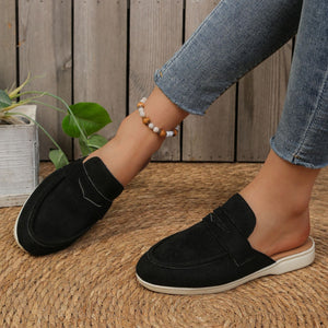 Black textured round toe slip-on loafers with a backless design.