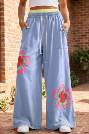 Light blue cotton maternity pants with wide legs and floral appliques