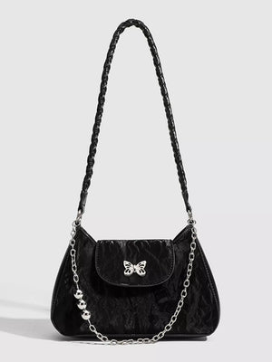 Black shoulder bag with textured fabric, butterfly clasp, beaded chain, and braided strap.