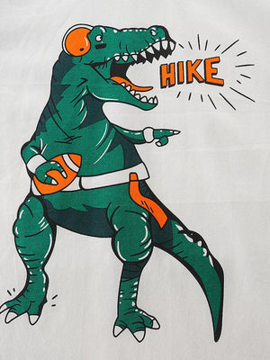 Graphic tee with green dinosaur holding football and saying HIKE