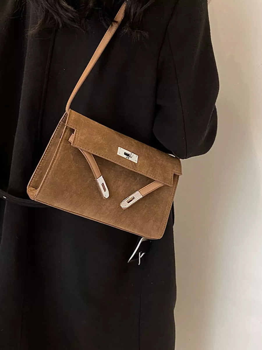 Elegant buckle shoulder bag in coffee color suede with silver hardware.