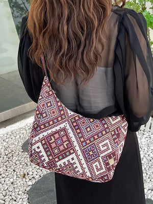 Embroidered geometric hobo bag in burgundy with colorful stitching and a casual slouchy style.