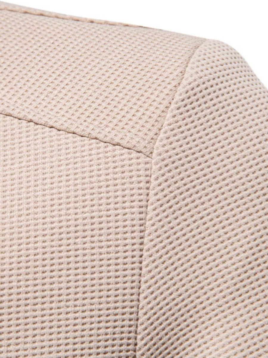 Taupe textured knit bomber jacket detail showing waffle weave fabric and seam.