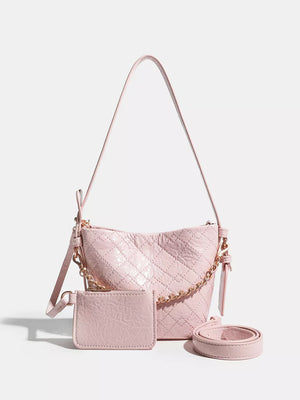 Pink quilted bucket bag with chain accent and matching card holder
