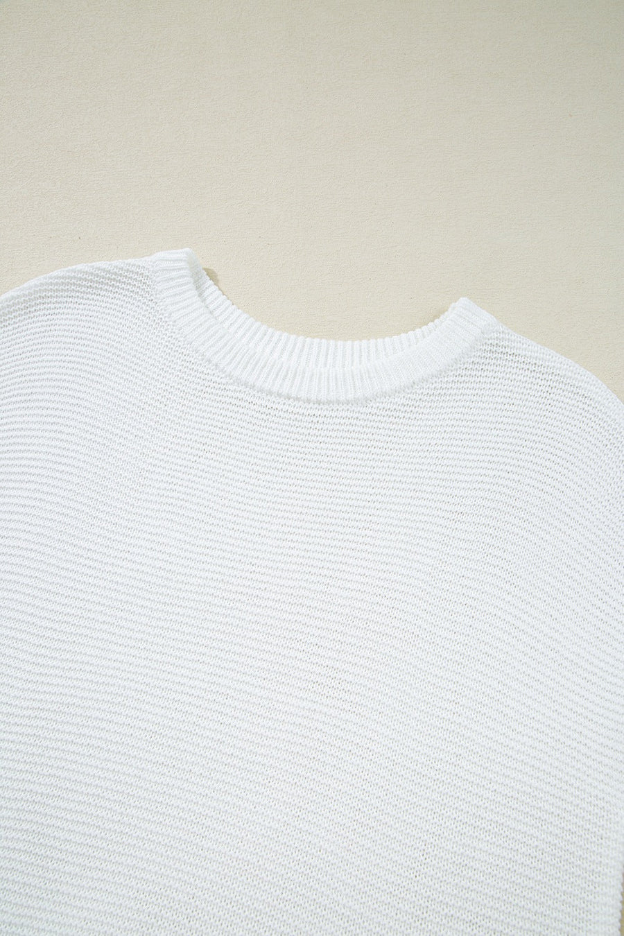White boxy knit crop top with crew neck and ribbed trim.